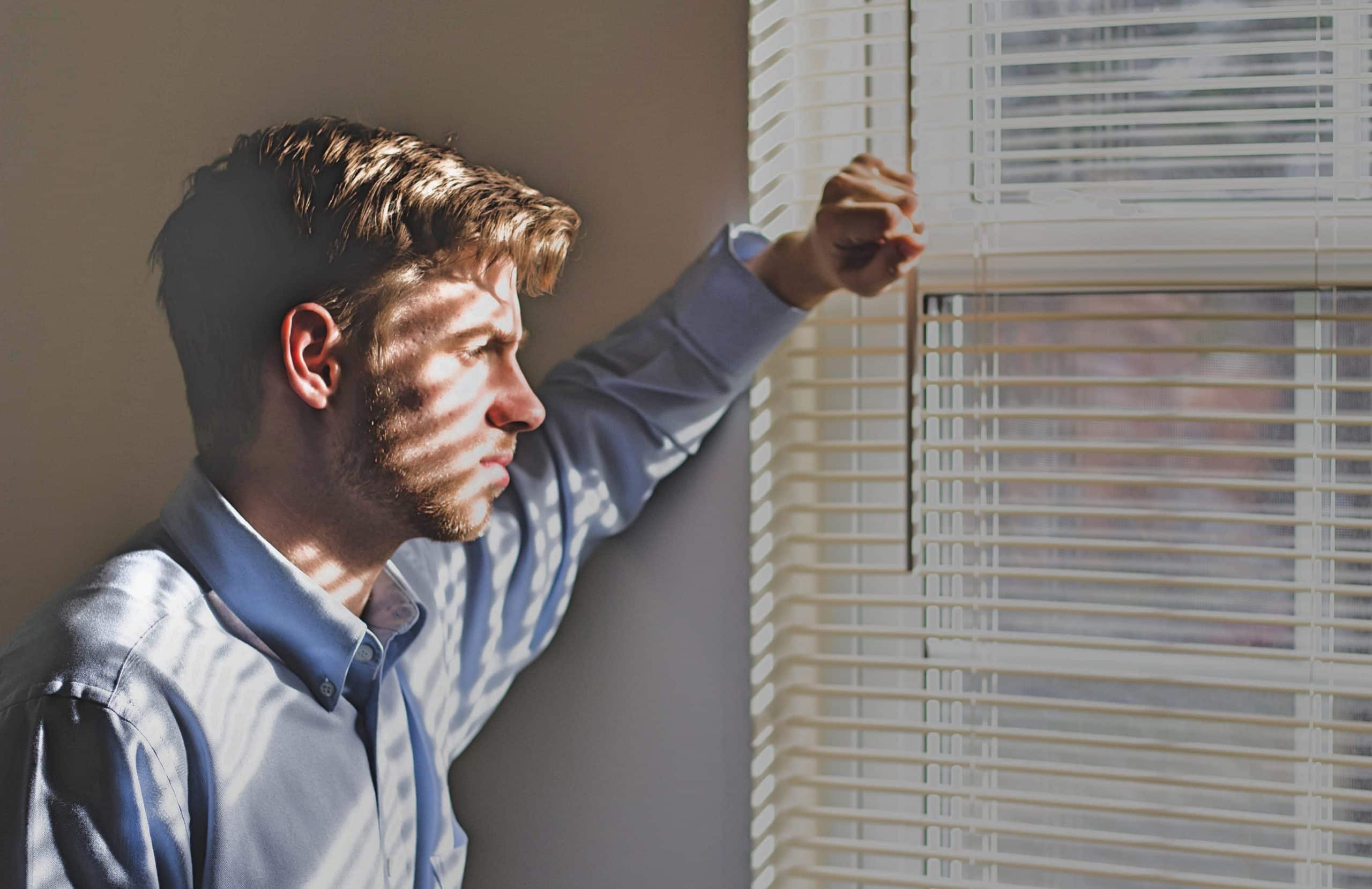 Man met weinig stressbestendigheid kijkt uit het raam